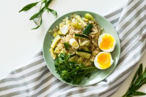 Nutritious bowl with rice, boiled egg, and coriander leaves - a heart-healthy meal to lower cholesterol through diet